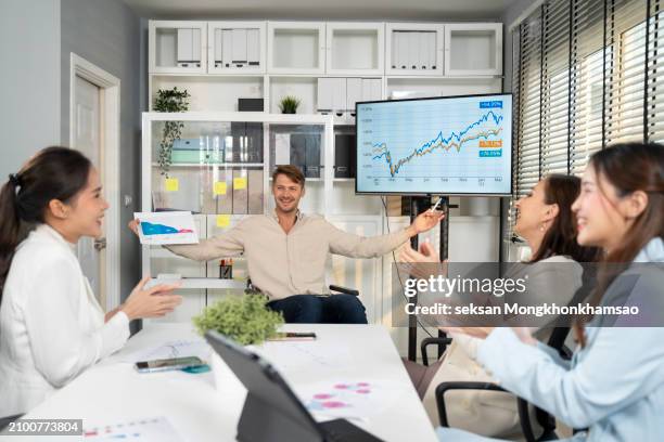 disabled business man in wheelchair giving presentation to colleagues. - inclusion body stockfoto's en -beelden