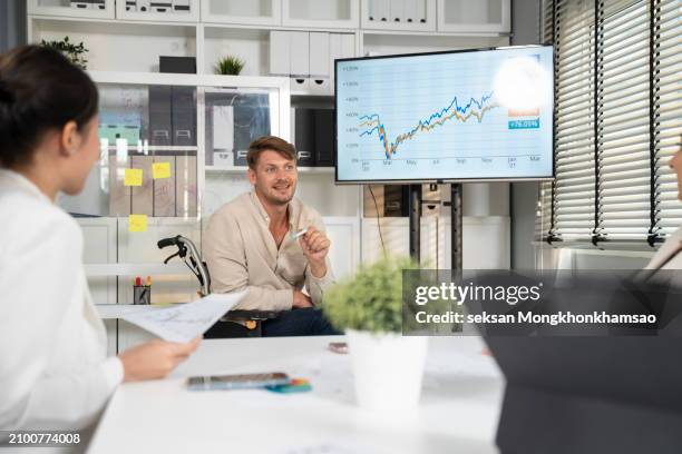 disabled business man in wheelchair giving presentation to colleagues. - inclusion body stock-fotos und bilder