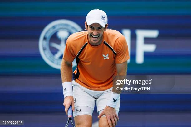 Andy Murray of Great Britain laughs to his team after missing a shot against Matteo Berrettini of Italy in the first round of the Miami Open at the...