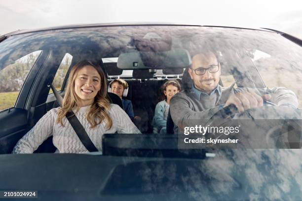 happy family going on a vacation by car. - voorruit stockfoto's en -beelden