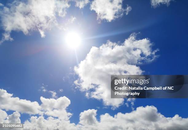 sunlight between cumulus clouds in blue sky in wellington, new zealand - mezzogiorno foto e immagini stock
