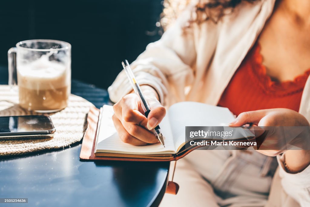 Woman Writing in her Notebook, Making a To-do List.