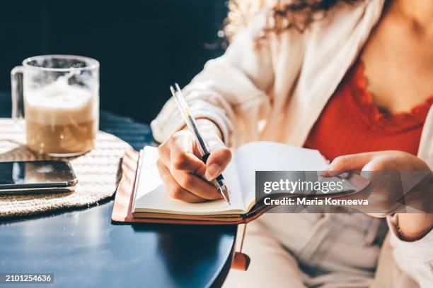 woman writing in her notebook, making a to-do list. - note pad stock pictures, royalty-free photos & images