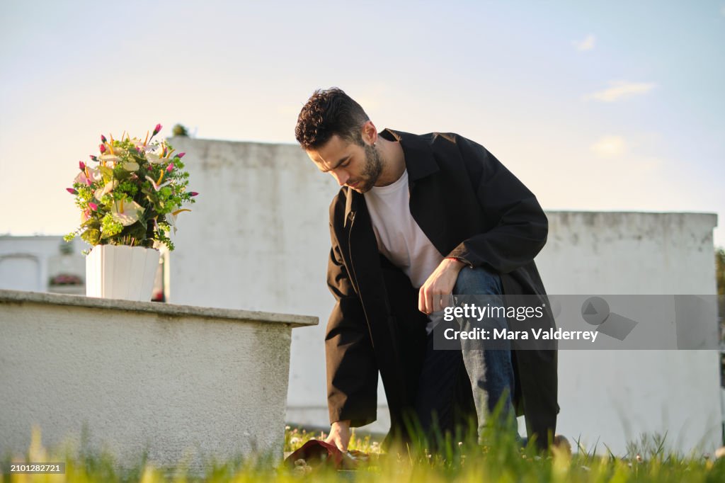 Homem triste trazendo flores no cemitério