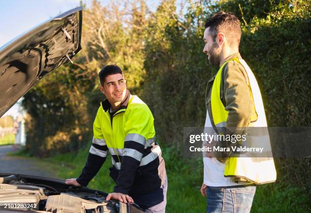 mechanic and man talking next to broken car - miss mara stock pictures, royalty-free photos & images
