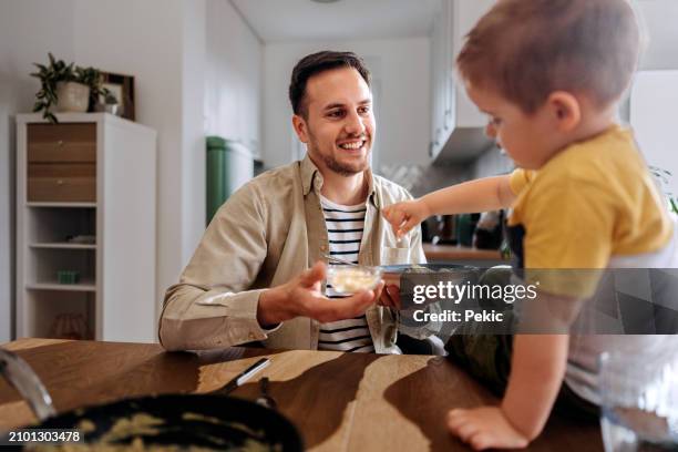 padre e figlio che si godono un pasto insieme a casa - parmigiano foto e immagini stock