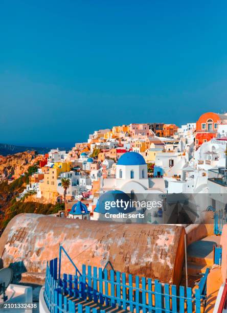 beautiful summer vacation landscape of iconic blue domed churches along the caldera edge at sunny morning against clear blue sky in oia, santorini, caldera, greek islands, greece - mediterranean-blue-roof-santorini stock pictures, royalty-free photos & images