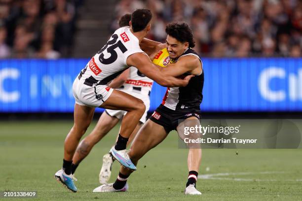 Mitch Owens of the Saints fends of Nick Daicos of the Magpies during the round two AFL match between St Kilda Saints and Collingwood Magpies at...