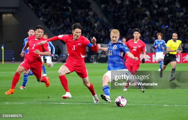 Daizen Maeda of Japan shoots whilst under pressure from Jang Kuk Chol of North Korea during the FIFA World Cup Asian 2nd qualifier Group B between...
