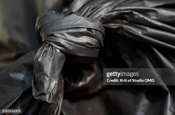 tie knot black garbage bag, waste management concept - müllsack stock-fotos und bilder