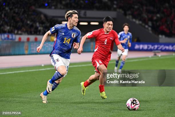 Daiki Hashioka of Japan runs with the ball whilst under pressure from Kim Pom Hyok of North Korea during the FIFA World Cup Asian 2nd qualifier Group...