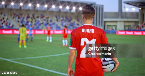 jugador de fútbol de pie en el campo de fútbol - traje de fútbol fotografías e imágenes de stock