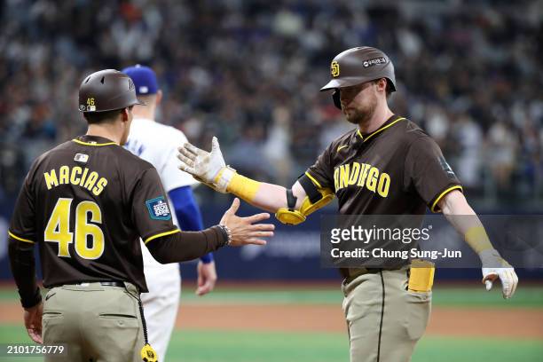 Jake Cronenworth of the San Diego Padres celebrates with David Macias after hitting a RBI single in the 5th inning during the 2024 Seoul Series game...