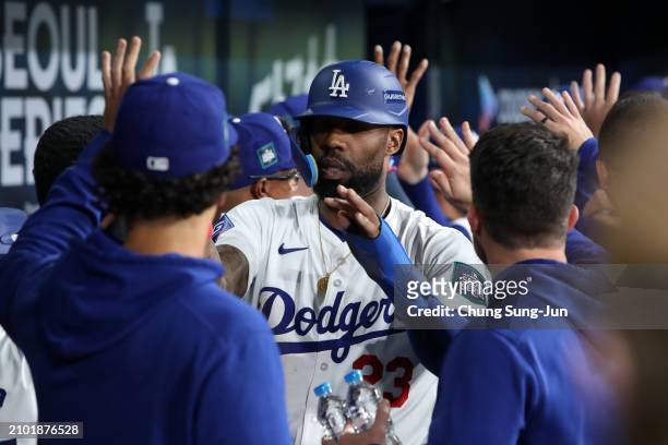 Jason Heyward of the Los Angeles Dodgers celebrates with teammates after scoring a run by a RBI single of Mookie Betts in the 8th inning during the...