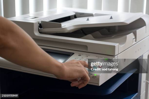 bussiness man hand press button on panel of printer, printer scanner laser in office copy machine supplies start concept - imprimante photos et images de collection