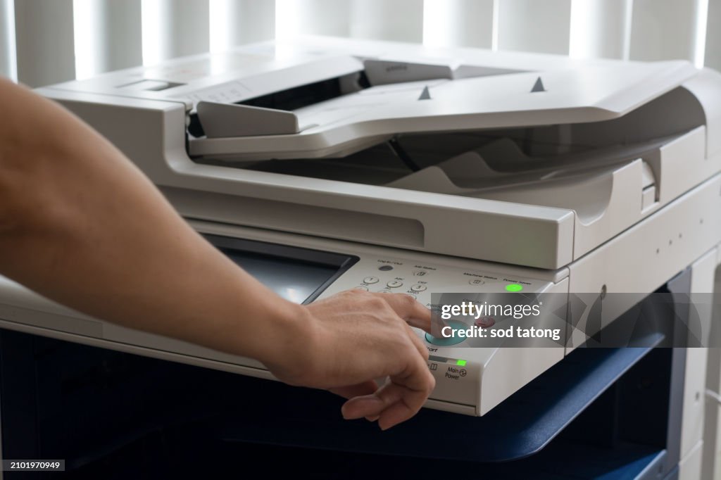 Bussiness man Hand press button on panel of printer, printer scanner laser in office copy machine supplies start concept