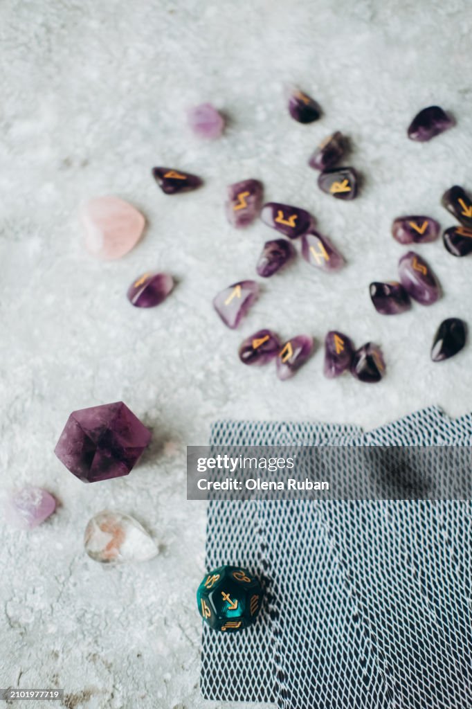 Crystals, cards and violet stones with engraved runes.