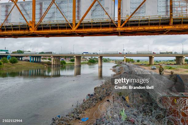 In an aerial view, Texas National Guard soldiers patrol atop barriers of shipping containers on the banks of the Rio Grande river near Shelby Park on...