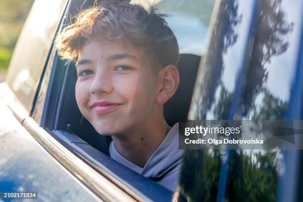 a smiling teenager leaning out through an open window car - open day 13 stock pictures, royalty-free photos & images