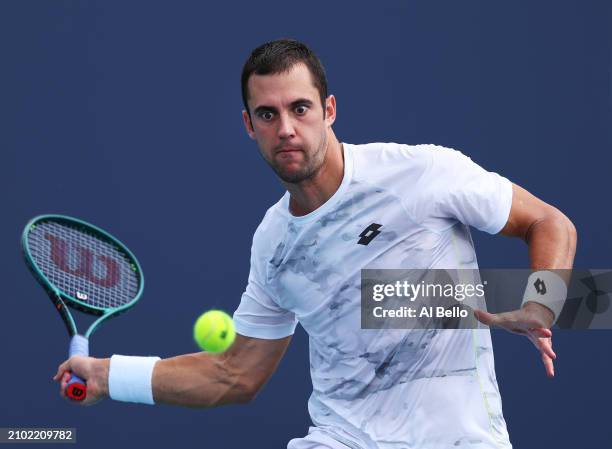 Laslo Djere of Serbia returns a shot against Coleman Wong of Hong Kong during their match on Day 6 of the Miami Open at Hard Rock Stadium on March...