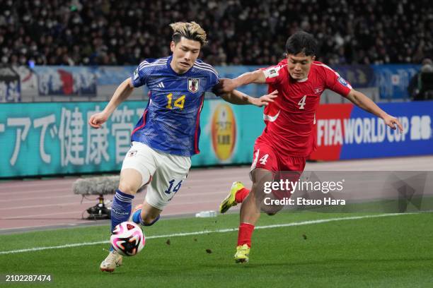 Daiki Hashioka of Japan and Pom Hyok Kim of North Korea compete for the ball during the FIFA World Cup Asian 2nd qualifier match between Japan and...