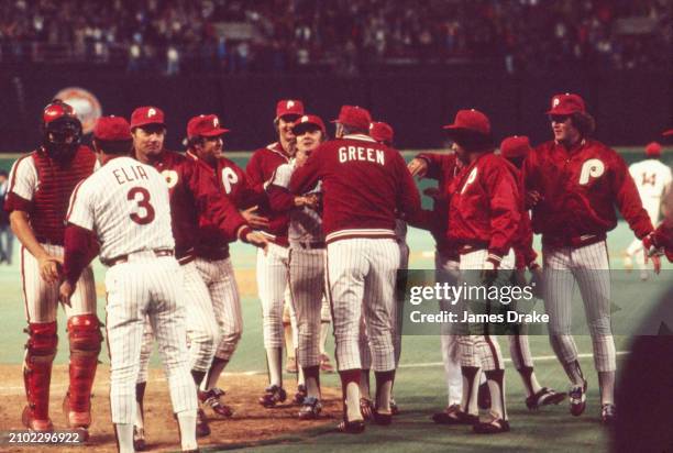 Philadelphia Phillies celebrate as manager Dallas Green congratulates pitcher Tug McGraw for striking out the final Kansas City Royals batter in Game...