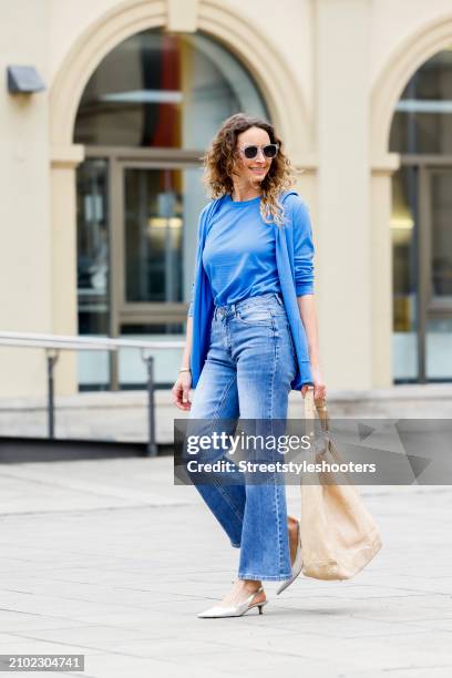 Sarah Kaldewey, wearing a blue cardigan and shirt by Eva Lutz, a blue Jenas by Eva Lutz, sunglasses by Barton, silver sandals by Voile Blanche and a...