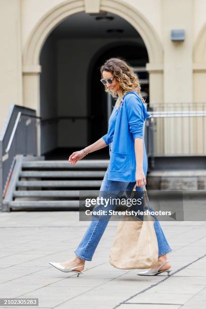 Sarah Kaldewey, wearing a blue cardigan and shirt by Eva Lutz, a blue Jenas by Eva Lutz, sunglasses by Barton, silver sandals by Voile Blanche and a...
