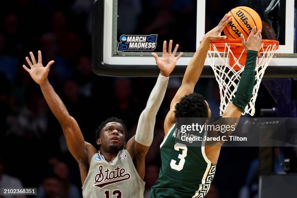 Jaden Akins of the Michigan State Spartans dunks the ball against Josh Hubbard of the Mississippi State Bulldogs during the second half in the first...