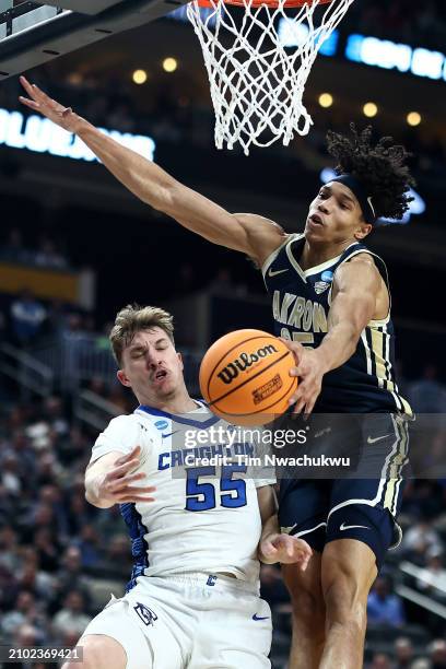 Baylor Scheierman of the Creighton Bluejays and Enrique Freeman of the Akron Zips battle under the basket in the first half in the first round of the...