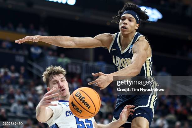 Baylor Scheierman of the Creighton Bluejays and Enrique Freeman of the Akron Zips battle under the basket in the first half in the first round of the...