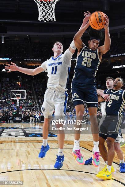 Ryan Kalkbrenner of the Creighton Bluejays and Enrique Freeman of the Akron Zips go for a rebound under the basket in the first half in the first...