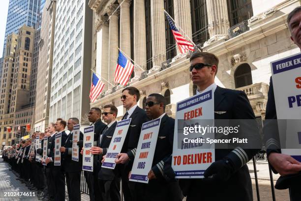 FedEx pilots stand in a silent protest outside of the New York Stock Exchange on March 21, 2024 in New York City. Coming ahead of the release of...