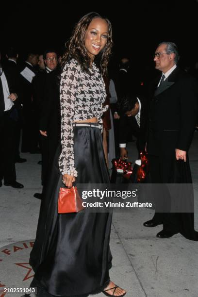 American model Tyra Banks, wearing a black-and-white tie-front blouse and a long black skirt, attends the 7th Annual Vanity Fair Oscar Party, held at...