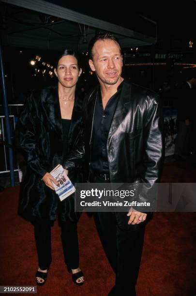 American sound engineer Kim Fey and her husband, American singer and actor Donnie Wahlberg, wearing a black leather jacket, attend the Westwood...