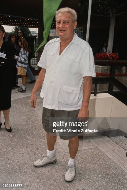 American comedian and actor Rodney Dangerfield, wearing a white short-sleeve shirt and khaki shorts, attends the Century City premiere of 'Home Alone...