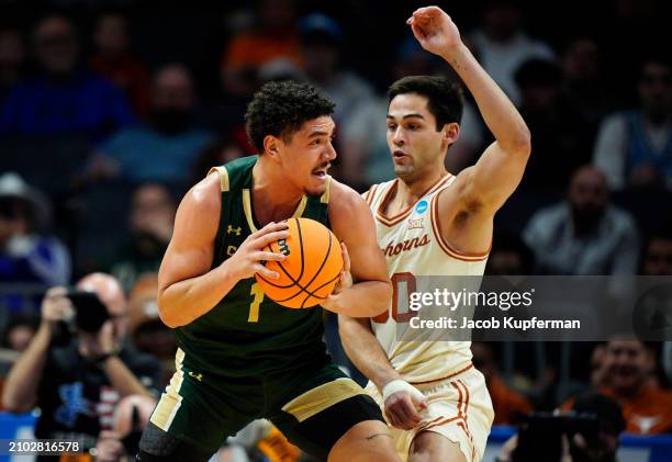 Joel Scott of the Colorado State Rams drives to the basket against Brock Cunningham of the Texas Longhorns during the first half in the first round...