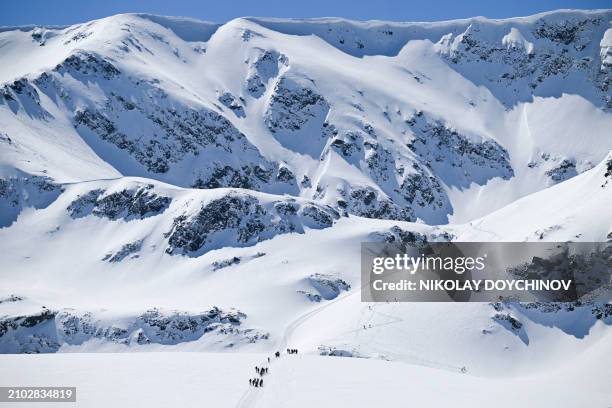 Volunteers pull people with disabilities on snow stretchers, under the Little Kabul peak at 2507 meter high, as they climb the Rila Mountain,...