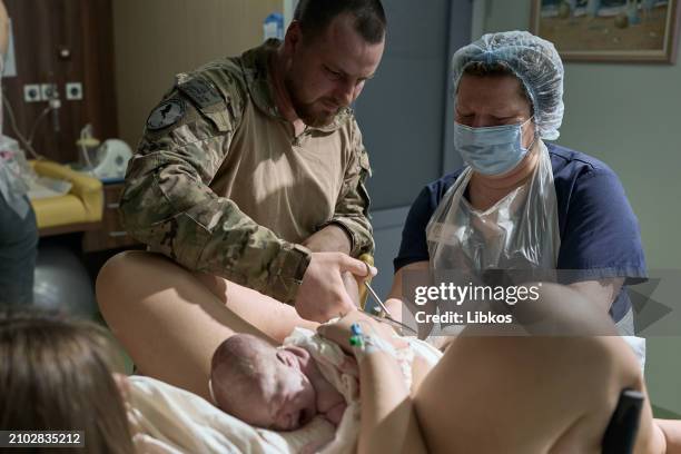 Father Dmytro cuts the umbilical cord during the first seconds of Lina's life born to Dmytro "Drongo" and his wife Lyubov during a partner birth at...