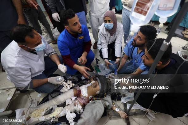 Graphic content / Medics provide urgent medical care to a child injured in Israeli bombardment, as she lieson the floor at the al-Najjar hospital in...