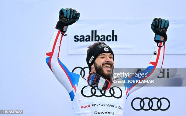 The second placed in the overall Men's Downhill competition of the FIS Alpine Skiing World Cup France's Cyprien Sarrazin celebrates on the podium...