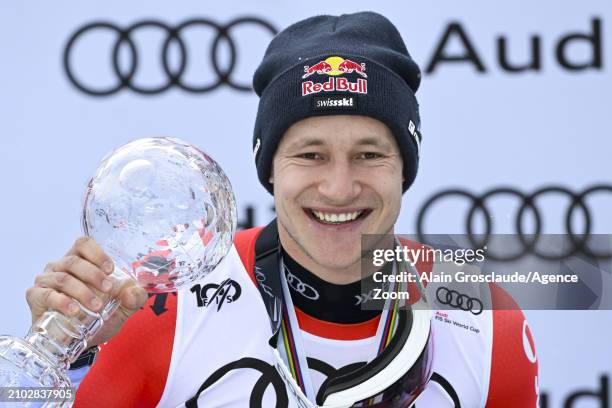 Marco Odermatt of Team Switzerland wins the globe in the overall standings during the Audi FIS Alpine Ski World Cup Finals Men's Downhill on March...