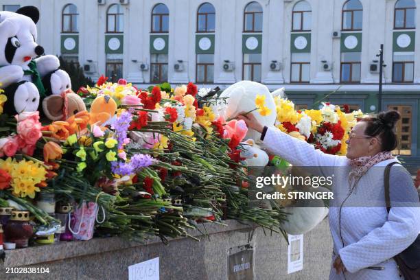 Woman lays flowers at a makeshift memorial in Simferopol, Crimea, on March 24 as Russia observes a national day of mourning after a massacre in the...