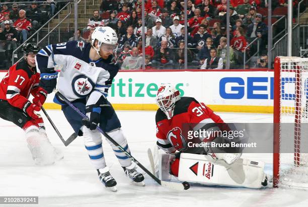 Jake Allen of the New Jersey Devils makes the first period save on Kyle Connor of the Winnipeg Jets at Prudential Center on March 21, 2024 in Newark,...