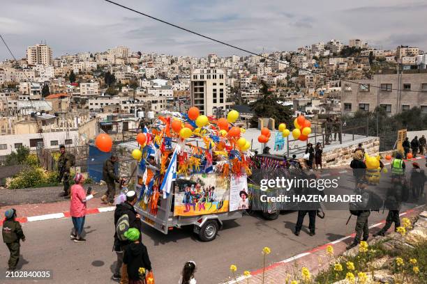 Israeli border guards and policemen escort revellers along Al-Shuhada street, which is largely closed to Palestinians, in the divided city of Hebron...