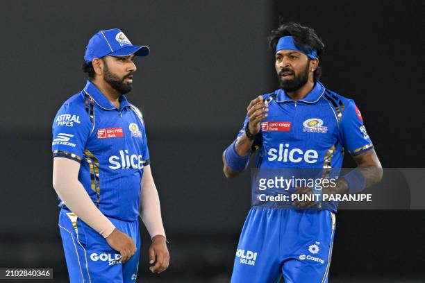 Mumbai Indians' captain Hardik Pandya and his teammate Rohit Sharma gesture during the Indian Premier League Twenty20 cricket match between Gujarat...