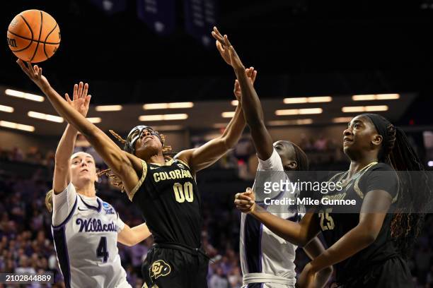 Jaylyn Sherrod of the Colorado Buffaloes shoots the ball against Serena Sundell of the Kansas State Wildcats and Eliza Maupin of the Kansas State...