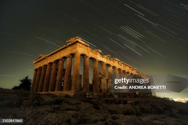 Star trails over the Parthenon temple at the Acropolis hill, Athens, Greece, during earth hour, on March 23, 2024