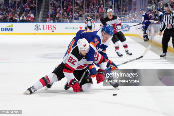 Casey Cizikas of the New York Islanders battles for puck against Santeri Hatakka of the New Jersey Devils at UBS Arena on March 24, 2024 in Elmont,...