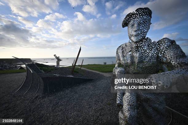 This photograph taken on March 24 shows a statue part of the D-day garden in the foreground and ruins of the British Artificial harbour in the...